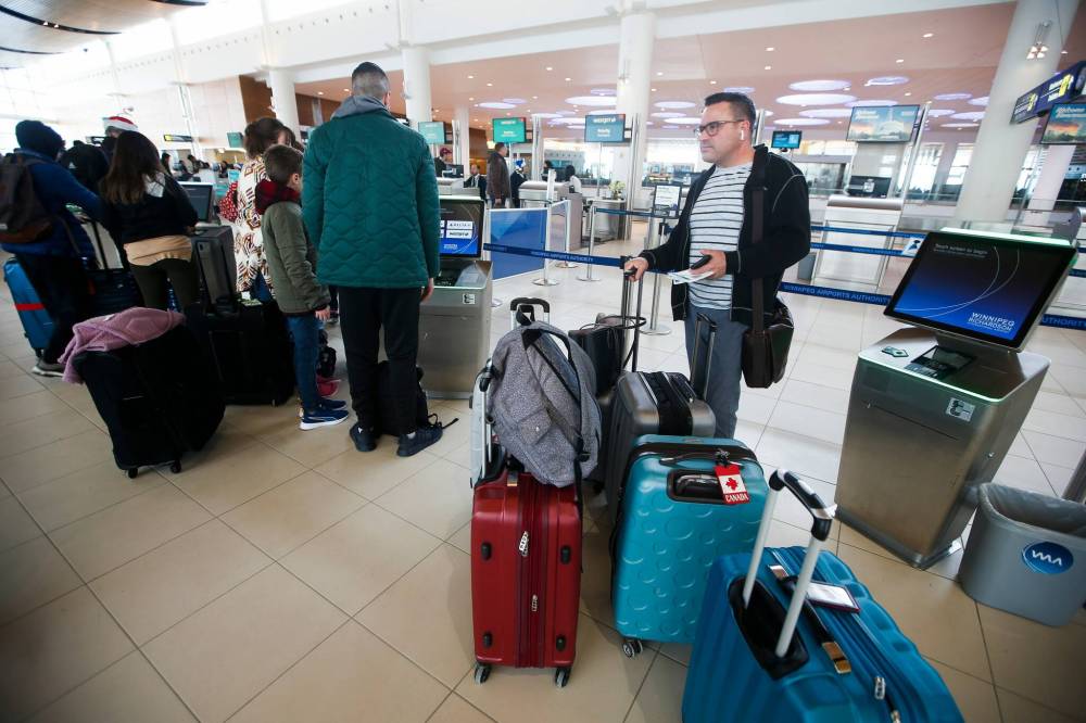 JOHN WOODS / WINNIPEG FREE PRESS
Ed Stemkoski and other travellers gather at Winnipegճ airport as they try to board flights.