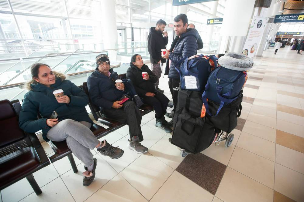 JOHN WOODS / WINNIPEG FREE PRESS
Khushbu Patel, left, assists Bharatbhai Patel, centre and his wife Meenaben, (not shown) as they wait at Winnipegճ airport as they try to board a flight to India.