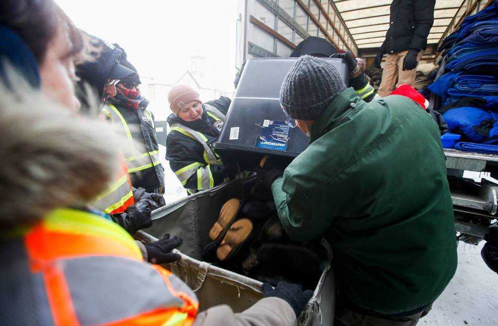 JOHN WOODS / WINNIPEG FREE PRESS
Volunteers with the Bear Clan deliver warm clothing items to a shelter at 190 Disraeli on Christmas Day.