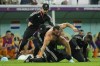 A pitch invader is tackled by security during the World Cup quarterfinal soccer match between the Netherlands and Argentina, at the Lusail Stadium in Lusail, Qatar, Friday, Dec. 9, 2022. (AP Photo/Francisco Seco)