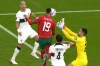 Morocco's Youssef En-Nesyri, centre, scores his side's opening goal during the World Cup quarterfinal soccer match between Morocco and Portugal, at Al Thumama Stadium in Doha, Qatar, Saturday, Dec. 10, 2022. (AP Photo/Alessandra Tarantino)