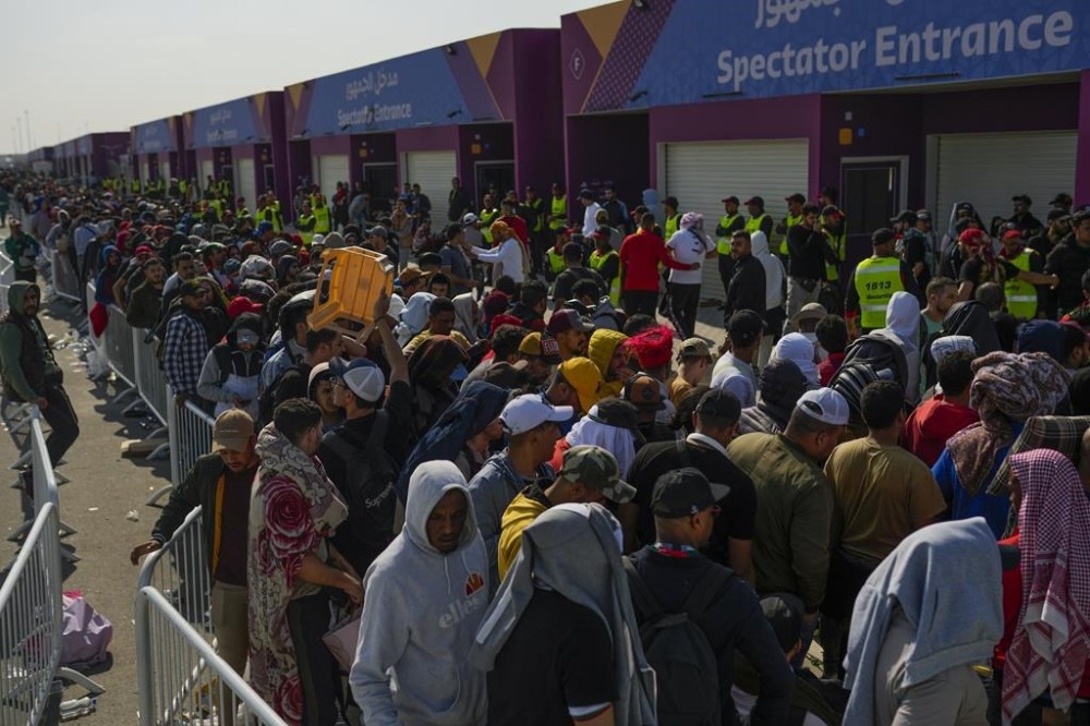 FILE - Fans queue outside of the Al Janoub Stadium in Wakrah, Qatar on Tuesday, Dec. 13, 2022 in the hope of getting tickets for Wednesday's World Cup semifinal soccer match between France and Morocco. (AP Photo/Francisco Seco, File)
