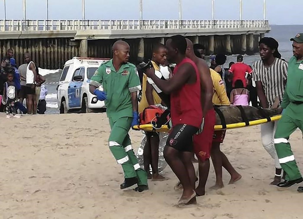 Paramedics carry a person on a stretcher on the Bay of Plenty Beach in Durban, South Africa, Saturday, Dec. 17, 2022. South Africa’s coastal city of Durban has closed its North Beach after three people died when they were caught in a freak wave. Emergency services spokesman Njabulo Dlungele said on Sunday that a freak wave swept a group of beachgoers against a pier, causing the deaths. (AP Photo)