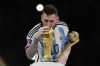 Argentina's Lionel Messi lisses the trophy after winning the World Cup final soccer match between Argentina and France at the Lusail Stadium in Lusail, Qatar, Sunday, Dec. 18, 2022. Argentina won 4-2 in a penalty shootout after the match ended tied 3-3. (AP Photo/Martin Meissner)
