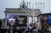 People attend the official lighting of a giant Hanukkah Menorah, set up by the Jewish Chabad Educational Center ahead of the Jewish Hanukkah holiday, in front of the Brandenburg Gate at the Pariser Platz in central Berlin, Germany, Sunday, Dec. 18, 2022. Holocaust survivors from around the world are marking the third day of Hanukkah in a virtual ceremony online as Jews are worrying about a sharp increase in antisemitism in the U.S., Europe and elsewhere. (AP Photo/Markus Schreiber)