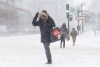 A woman crosses a near deserted street in downtown Montreal during a winter snow storm on Monday, January 17, 2022. THE CANADIAN PRESS/Paul Chiasson