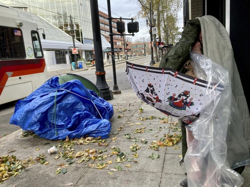 A homeless man who spent the night outside in temperatures that dipped into the single digits attempts to find shelter from the frigid cold on Thursday, Dec. 22, 2022, in Portland, Ore. (AP Photo/Gillian Flaccus)