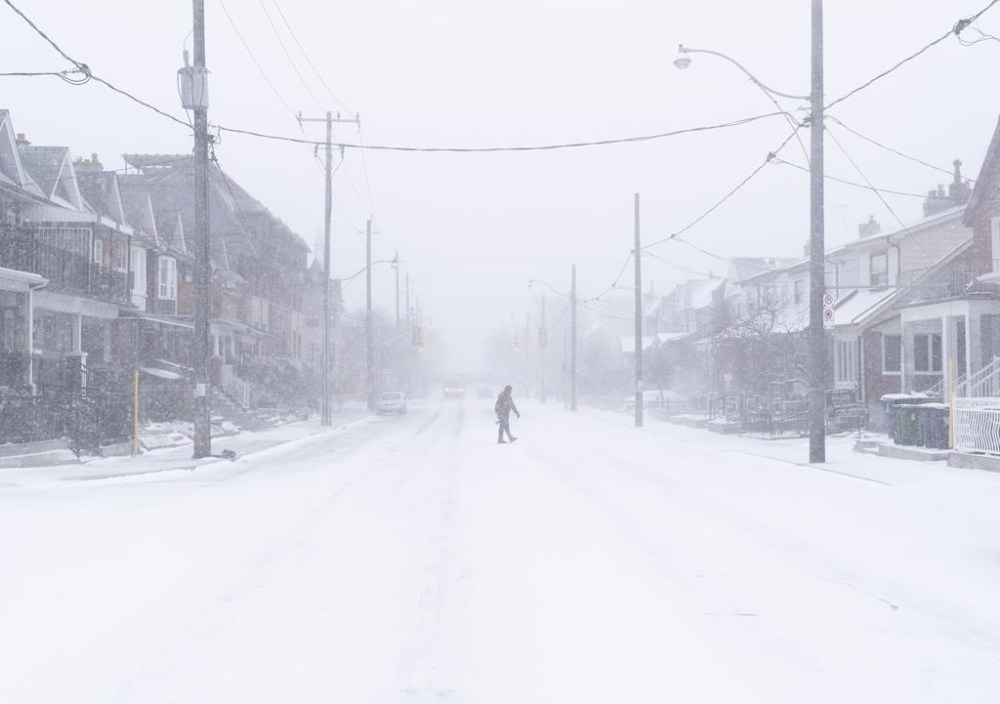 A man crosses a road during a snowstorm in Toronto on Friday, December, 23, 2022. A winter storm warning is in place for most of southern Ontario. THE CANADIAN PRESS/Arlyn McAdorey