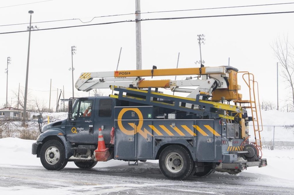 A Hydro Quebec truck is shown in an area without power in Montreal, Saturday, Dec. 24, 2022, following a winter storm in the region. Utility crews in Ontario, Quebec and New Brunswick are still working to restore electricity to thousands of customers who have been in the dark for days after last week's fierce winter storms knocked out their power. THE CANADIAN PRESS/Graham Hughes