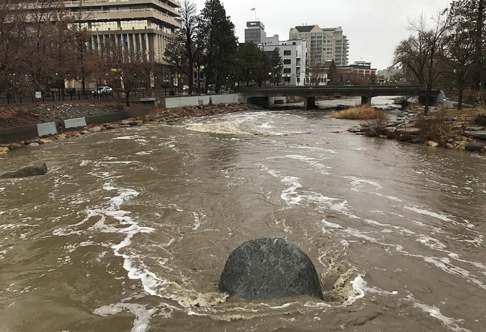 The Truckee River flows through Downtown Reno, Nev., during a winter storm on Tuesday, Dec. 27, 2022. Winter storm warnings have been issued Tuesday for the Sierra Nevada, where motorists are advised that the combination of winds and snow could make travel hazardous. (Jason Bean//The Reno Gazette-Journal via AP)
