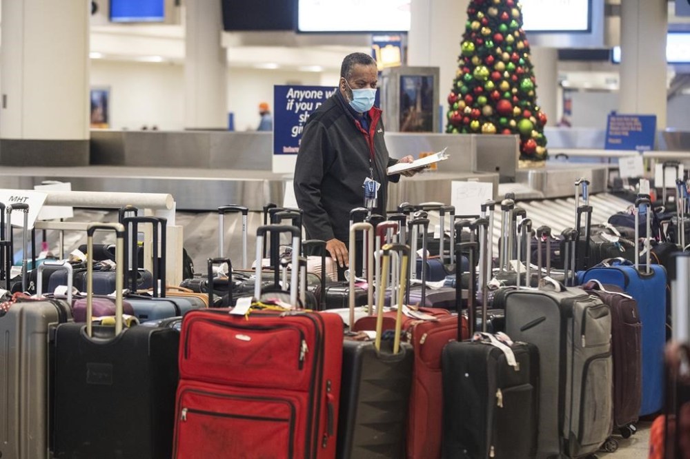 Airport staff looks around a pile of lost suitcases near the baggage carousel at Midway Airport in Chicago, Tuesday, Dec. 27, 2022, after Southwest Airlines flights were cancelled and delayed during a winter storm. Problems at Southwest Airlines appeared to snowball after the worst of the storm passed. It cancelled more than 70% of its flights Monday, more than 60% on Tuesday, and warned that it would operate just over a third of its usual schedule in the days ahead to allow crews to get back to where they needed to be. (Pat Nabong /Chicago Sun-Times via AP)