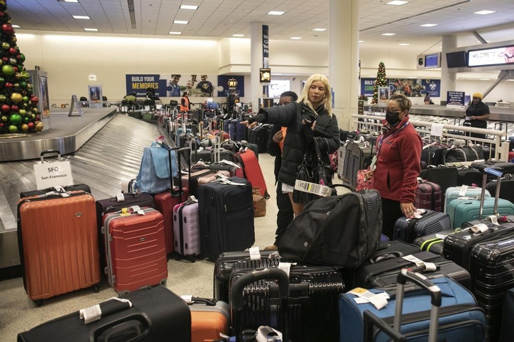 Itzel Enciso, 19, who is visiting Chicago from Los Angeles and said her bag was mistakenly tagged to arrive in Cleveland, looks for her lost luggage near the baggage carousel at Midway Airport in Chicago, Tuesday, Dec. 27, 2022, after Southwest Airlines flights were cancelled and delayed during a winter storm. Problems at Southwest Airlines appeared to snowball after the worst of the storm passed. It cancelled more than 70% of its flights Monday, more than 60% on Tuesday, and warned that it would operate just over a third of its usual schedule in the days ahead to allow crews to get back to where they needed to be. (Pat Nabong /Chicago Sun-Times via AP)