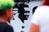 Fans of soccer star Pele walk past mural with an image of the player outside the Vila Belmiro stadium in Santos, Brazil, Thursday, Dec. 29, 2022. Pele, the Brazilian king of soccer who won a record three World Cups and became one of the most commanding sports figures of the last century, died in Sao Paulo. He was 82. (AP Photo/Fabricio Costa)