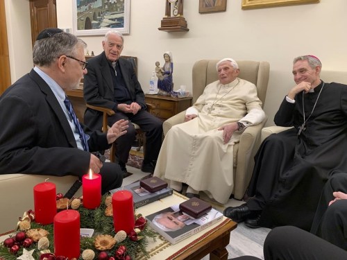 Pope Emeritus Benedict XVI, third from left, meets with the winners of the 2022 Ratzinger Prize, Joseph Halevi Horowitz Weiler, left, and father Michel Fedou, partially hidden at right, at the Mater Ecclesiae monastery inside the Vatican where Benedict XVI lives, in this photo taken Thursday, Dec. 1, 2022. Second from left, is the foundation's president Father Federico Lombardi, and fourth from left is Benedict XVI's long-time personal secretary Bishop Georg Gänswein. (Fondazione Vaticana J.Ratzinger via AP)