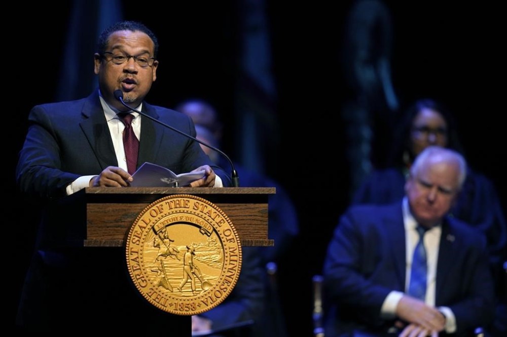 Minnesota Attorney General Keith Ellison delivers a speech as Minnesota Gov. Tim Walz, right, listens, during his inauguration for his second term, Monday, Jan. 2, 2023, in St. Paul, Minn. (AP Photo/Abbie Parr)