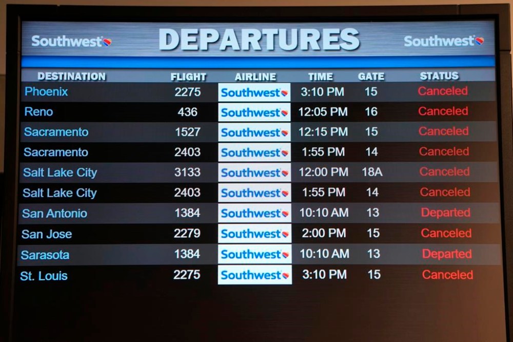 FILE - Canceled Southwest Airlines flights are displayed in red on the departures monitor at the Southwest terminal at the Los Angeles International Airport, Dec. 27, 2022. With its flights now running on a roughly normal schedule, Southwest Airlines is turning its attention to luring back customers and repairing damage to a reputation for service after canceling 15,000 flights around Christmas. The disruptions started with a winter storm and snowballed when Southwest's ancient crew-scheduling technology failed. (AP Photo/Damian Dovarganes, File)