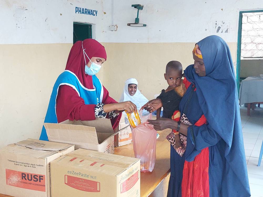 CLWR
A Somali woman picks up food for her child at the Dollow Referral Hospital.