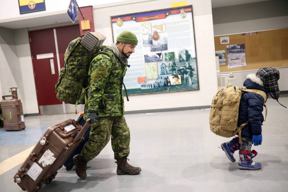 Tim Smith / Brandon Sun
Six-year-old Hudson Sparks carries his dad’s backpack. Master Cpl. Rory Sparks with 2nd Battalion, Princess Patricia’s Canadian Light Infantry, returned to CFB Shilo from Latvia Thursday night.