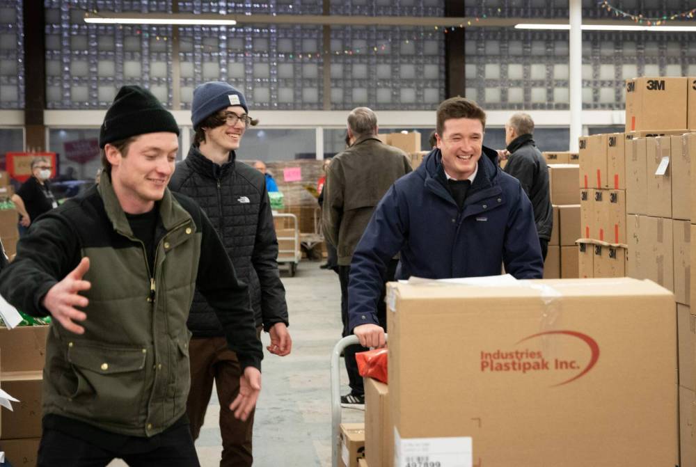 JESSICA LEE / WINNIPEG FREE PRESS
Volunteer delivery checkers perform a vital role at the Christmas Cheer Board. Adam (left), Jack and Simon Scott helped deliver gifts to families and their children.