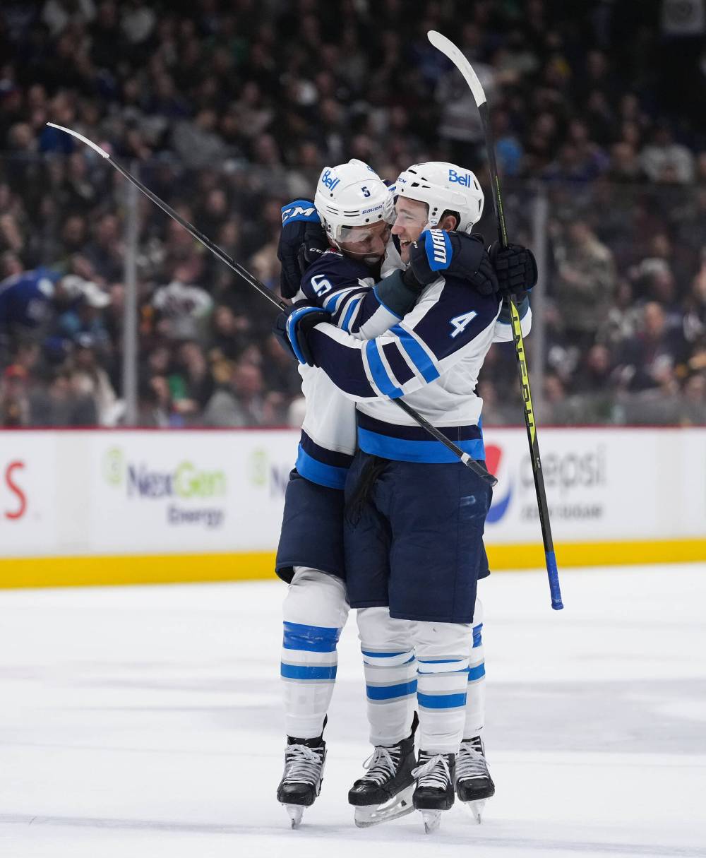 DARRYL DYCK / THE CANADIAN PRESS
Winnipeg Jets’ Brenden Dillon, left, and Neal Pionk celebrate Pionk’s goal against the Vancouver Canucks during the second period.