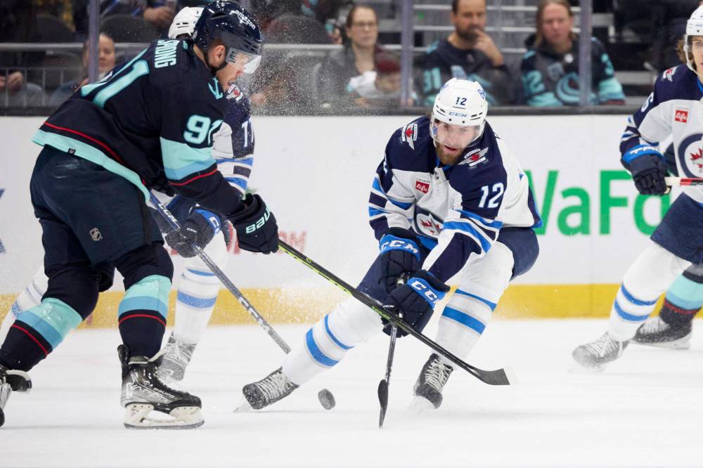 JOHN FROSCHAUER / THE ASSOCIATED PRESS
Seattle Kraken right wing Daniel Sprong battles for the puck with Winnipeg Jets center Jansen Harkins (12) during the first period.