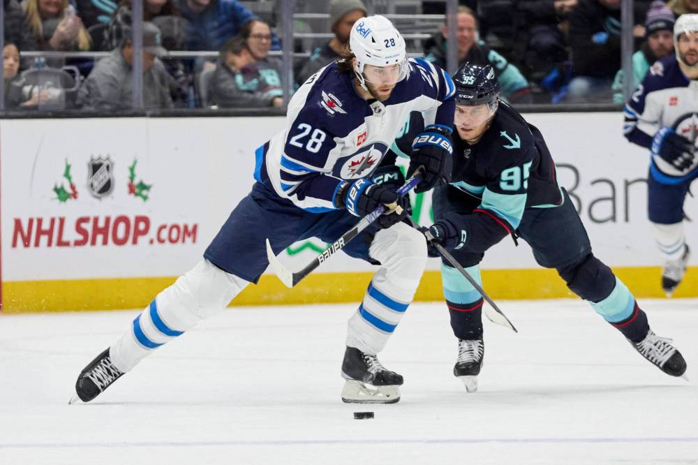 JOHN FROSCHAUER / THE ASSOCIATED PRESS
Winnipeg Jets center Kevin Stenlund (28) and Seattle Kraken left wing Andre Burakovsky (95) vie for the puck during the third period of an NHL hockey game, Sunday, Dec. 18, 2022, in Seattle.