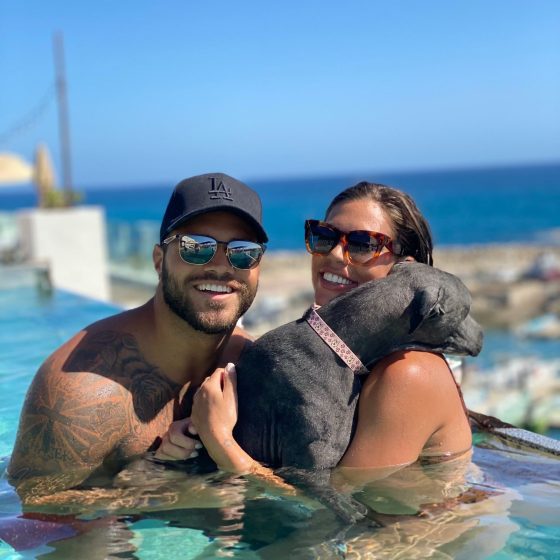 Bombers running back Brady Oliveira and Alex Blumberg take a dip with one of their four-legged amigos. (Supplied)