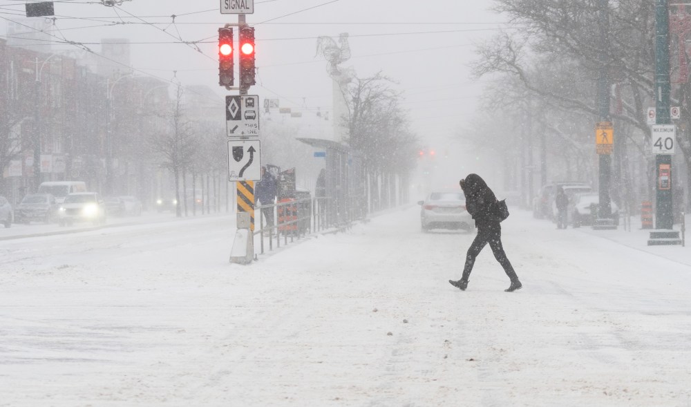 A person walks through blowing snow during a snowstorm in Toronto on Friday, December, 23, 2022. A winter storm warning is in place for most of southern Ontario. THE CANADIAN PRESS/Arlyn McAdorey