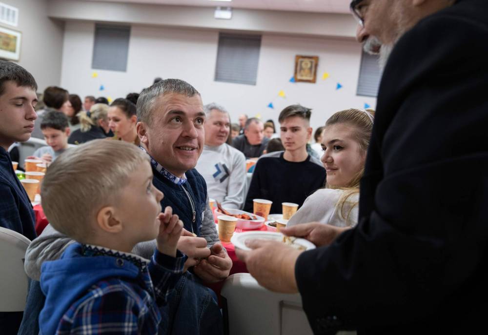 JESSICA LEE / WINNIPEG FREE PRESS
Liubomyr Zelenko (in black) is presented with communion bread. He celebrates Ukrainian Christmas Eve with his family Sviatoslav, 5, and Mariia, 18 (right) on Friday at Sts.Vladimir and Olga Cathedral.