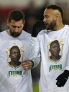 PSG's Lionel Messi, left, talks to PSG's Neymar, both wearing t-shirts commemorating the late Brazilian soccer great Pele, was they warm up for the French League One soccer match between Paris Saint-Germain and Angers at the Parc des Princes in Paris, France, Wednesday, Jan. 11, 2023. (AP Photo/Francois Mori)
