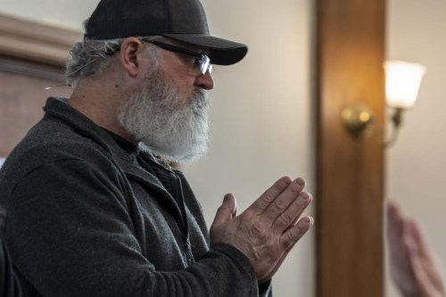 Boris Levins holds his hands in prayer while worshiping with Blue Jean Church as the city of Selma, Ala., recovers from a tornado several days earlier, Sunday, Jan. 15, 2023. (AP Photo/Vasha Hunt)