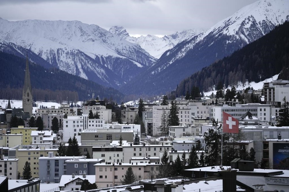 A Swiss national flag waves on a building in Davos, Switzerland, Sunday, Jan. 15, 2023. The annual meeting of the World Economic Forum is taking place in Davos from Jan. 16 until Jan. 20, 2023. (AP Photo/Markus Schreiber)