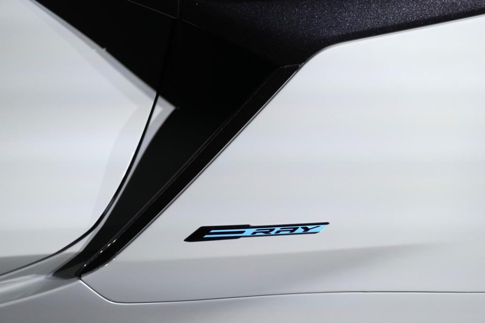 The 2024 Corvette E Ray badge is displayed, Thursday, Jan. 12, 2023, in Milford Mich. The fastest corvette ever made comes out next year, and it's not powered soley by the traditional howling V8. The E Ray is a gas electric hybrid, the first all wheel drive version of the storied sports car with the front wheels running on a battery. Aimed at affluent buyers who want new technology in the top-line Chevrolet sports car, the $104,000 E Ray jerks your head back as it goes from zero to 60 mph in 2.5 seconds. (AP Photo/Carlos Osorio)