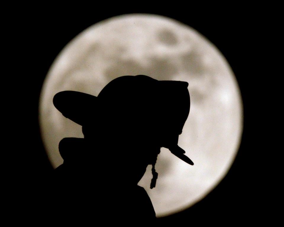 A firefighter is silhouetted against a full moon as he watches a fire from a ladder truck Monday, May 16, 2011 in Overland Park, Kan. Police say the Office of the Fire Marshal has declared a house explosion in Kitchener criminal in nature. THE CANADIAN PRESS/AP-Charlie Riedel