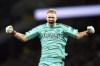 Arsenal goalkeeper Aaron Ramsdale celebrates their side's second goal of the game, scored by team-mate Martin Odegaard during the English Premier League match at the Tottenham Hotspur Stadium, London, Sunday Jan. 15, 2023. A spectator climbed onto an advertising board and appeared to kick Arsenal goalkeeper Aaron Ramsdale after the team’s 2-0 win over Tottenham in the Premier League. (Nick Potts/PA via AP)