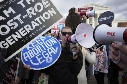 FILE - An abortion rights protestor, center, uses a megaphone as anti-abortion demonstrators rally outside the U.S. Supreme Court during the March for Life, Friday, Jan. 20, 2023, in Washington. (AP Photo/Alex Brandon, File)