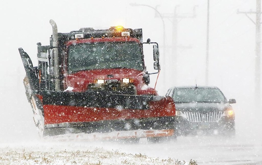 A South Dakota state snow plow clears a shoulder along Highway 50 on the north edge of Yankton, S.D., on Thursday, Dec. 15, 2022, as light snow swept by strong winds reduced visibility to a quarter-mile at times. Yankton is about 200 miles east of the Rosebud Sioux Reservation, which was battered by a mid-December snowstorm that left roads impassable. A 12-year-old asthmatic boy was among six people who died on the reservation during the storm. The tribe says all of the deaths could have been prevented were it not for systemic failures and a lack of timely help. (Kelly Hertz/Yankton Press & Dakotan via AP)