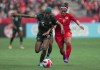 Nigeria's Rasheedat Ajibade, left, and Canada's Desiree Scott vie for the ball during the first half of a women's friendly soccer match, in Vancouver, on Friday, April 8, 2022. The Kansas City Current have re-signed captain Scott for the 2023 season.THE CANADIAN PRESS/Darryl Dyck