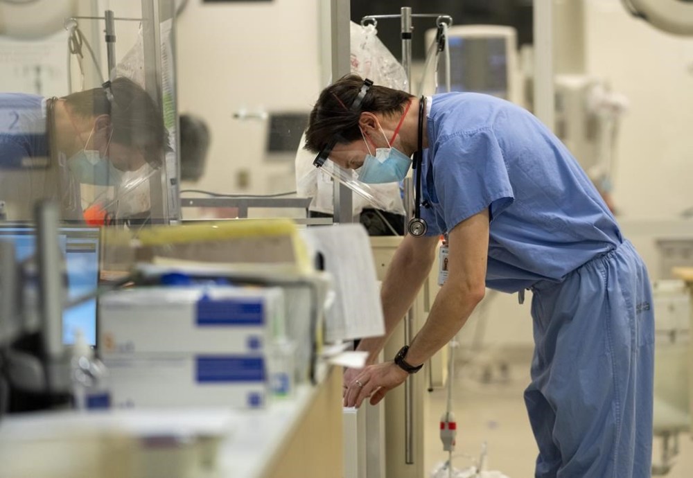 An emergency room physician looks a paperwork while providing care for patients in the emergency room at the Humber River Hospital during the COVID-19 pandemic in Toronto on Tuesday, Jan. 25, 2022. A new report from the Canadian Federation of Independent Business says that Canadian doctors spend 18.5 million hours per year on unnecessary administrative work. THE CANADIAN PRESS/Nathan Denette
