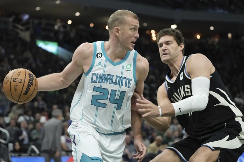 Charlotte Hornets' Mason Plumlee drives past Milwaukee Bucks' Brook Lopez during the first half of an NBA basketball game Tuesday, Jan. 31, 2023, in Milwaukee. (AP Photo/Morry Gash)