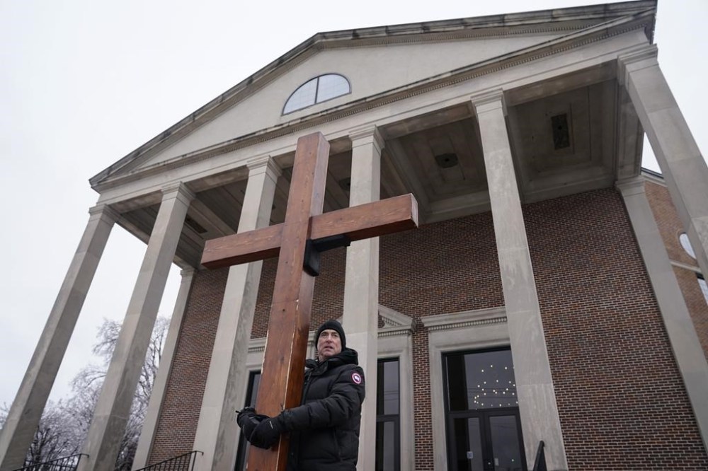Dan Beazley, of Memphis, Tenn., holds up a cross in front of the Mississippi Boulevard Christian Church, where the funeral service for Tyre Nichols will be held on Wednesday, Feb. 1, 2023, in Memphis, Tenn. Nichols was beaten by Memphis police officers, and later died from his injuries. (AP Photo/Jeff Roberson)