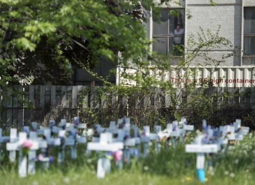 The head of the Canadian Labour Congress says new standards to improve the quality of long-term care are not enough to address the serious staff issues that led to dismal and deadly conditions for seniors during the COVID-19 pandemic. A man looks out the window at the Camilla Care Community centre overlooking crosses marking the deaths of multiple people that occurred during the COVID-19 pandemic in Mississauga, Ont., on May 26, 2020. THE CANADIAN PRESS/Nathan Denette