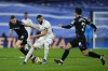 Real Madrid's Karim Benzema, center, controls the ball between Real Sociedad's Igor Zubeldia, left, and Martin Zubimendi during the Spanish La Liga soccer match between Real Madrid and Real Sociedad, at the Santiago Bernabeu stadium in Madrid, Sunday, Jan. 29, 2023. (AP Photo/Manu Fernandez)