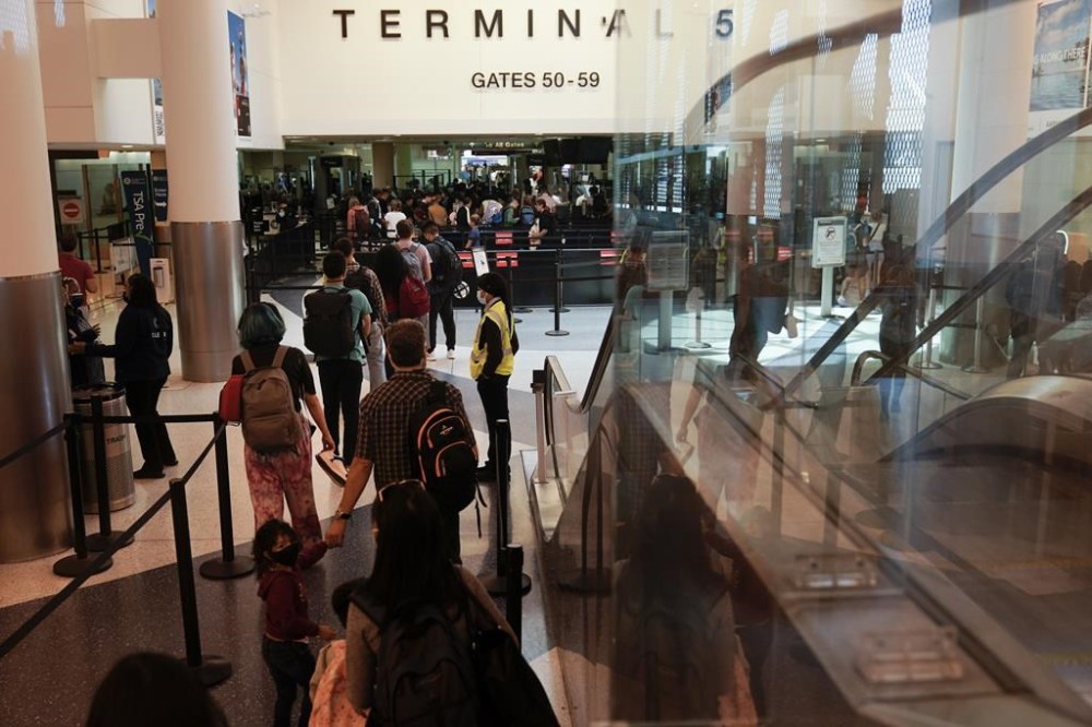 FILE - Travelers wait in line at a TSA security check at the Los Angeles International Airport in Los Angeles, on July 1, 2022. Power was briefly knocked out at Los Angeles International Airport on Wednesday, Feb. 1, 2023, leaving many passengers at one of the world's busiest airports in the dark and halting security checks. (AP Photo/Jae C. Hong, File)