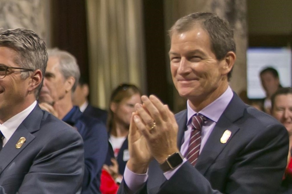 FILE- Gene Sykes claps after City Council voted 12-0 to endorse documents at the heart of its plan to stage the Summer Olympics for the third time since 1932, in Los Angeles on Aug. 11, 2017. The new leader of the U.S. Olympic and Paralympic Committee has reiterated the federation’s support for exploring a way for Russian athletes to compete at the Paris Olympics as neutrals. (AP Photo/Damian Dovarganes, File)