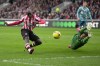 Southampton's goalkeeper Gavin Bazunu dives to save a shot from Brentford's Yoane Wissa, left, during the English Premier League soccer match between Brentford and Southampton at Brentford Community Stadium in London, Saturday, Feb. 4, 2023. (AP Photo/Kin Cheung)