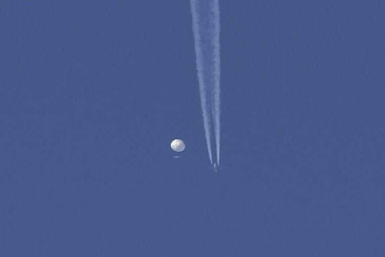 In this photo provided by Brian Branch, a large balloon drifts above the Kingston, N.C., area, with an airplane and its contrail seen below it. The federal defence minister says Canada 