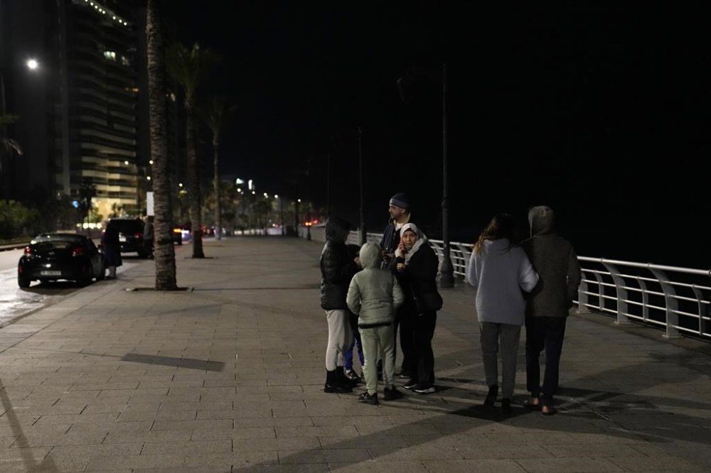A family stay outside after an earthquake hit neighboring Turkey early Monday, Feb. 6, 2023, in Beirut, Lebanon. Many residents in Lebanon left their homes and took to the streets or drove in their cars away from buildings. A powerful earthquake hit southeast Turkey and Syria early Monday, toppling buildings and sending panicked residents pouring outside in a cold winter night. (AP Photo/Hussein Malla)