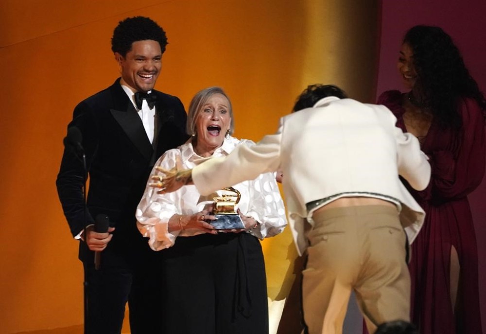 Harry Styles fan, Reina Fafantaisie, center, presents Harry Styles, right, with the award for album of the year for