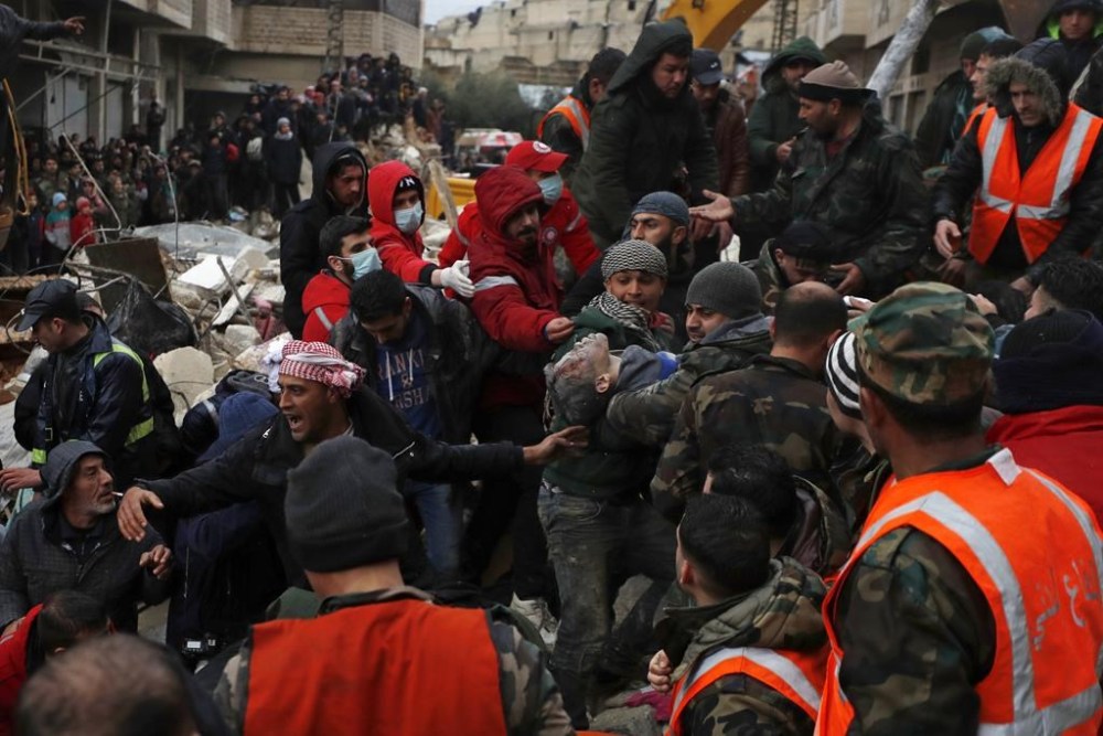 Civil defense workers and security forces carry an earthquake victim as they search through the wreckage of collapsed buildings in Hama, Syria, Monday, Feb. 6, 2023. A powerful earthquake has caused significant damage in southeast Turkey and Syria and many casualties are feared. Damage was reported across several Turkish provinces, and rescue teams were being sent from around the country. (AP Photo/Omar Sanadik)